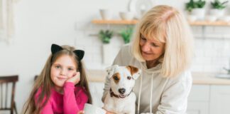 Grandmother With Granddaughter Sitting With Dog