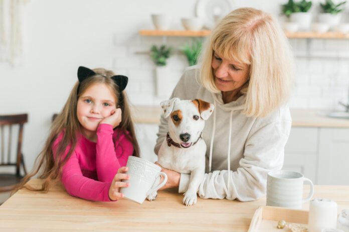 Grandmother With Granddaughter Sitting With Dog