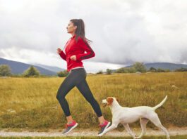 Young woman jogging with her dog