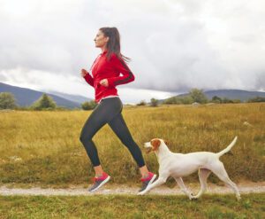 Young woman jogging with her dog