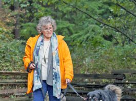 Woman taking her dog for a walk on a forest path