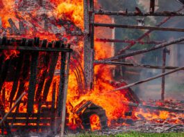 A fire in a residential neighborhood consumes a dog house.