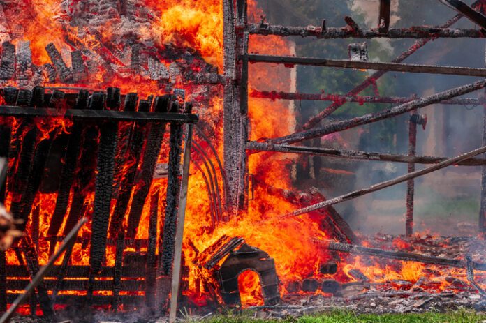 A fire in a residential neighborhood consumes a dog house.