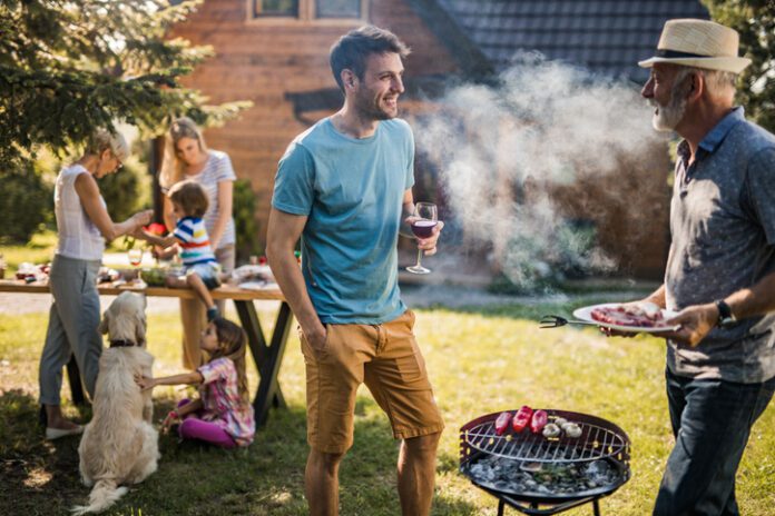 Happy men talking while preparing barbecue for his family in the backyard. Dogs often have a completely different experience at events that their owners regard as happy and fun.